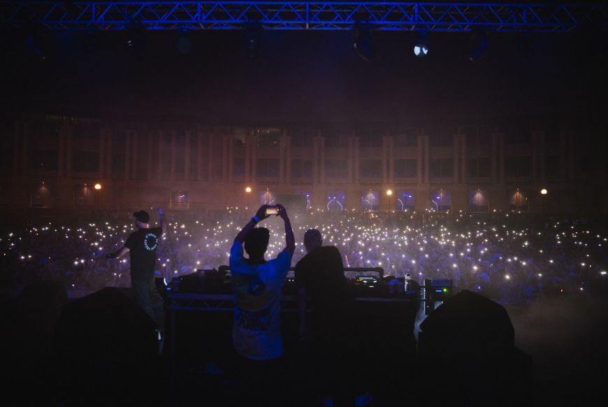 people DJ-ing to big crowd at night